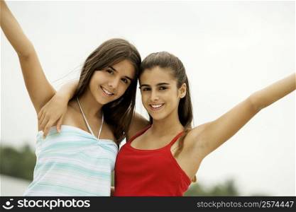 Portrait of two teenage girls with their arms around each other