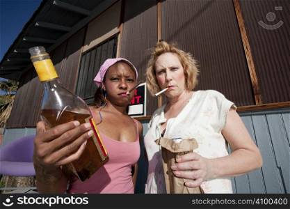Portrait of two trashy drunk women outdoors