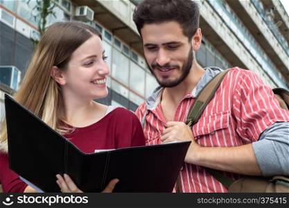 Portrait of two University students studying together at the building of university. Education concept