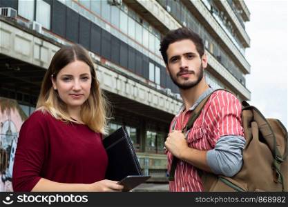 Portrait of two University students studying together at the building of university. Education concept