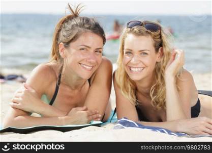 portrait of two women layed on the beach