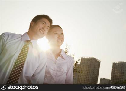 Portrait of two young business people leaning forward, close-up, brightly lit