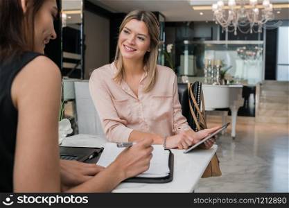 Portrait of two young businesswomen having meeting in a hotel lobby. Business travel concept.