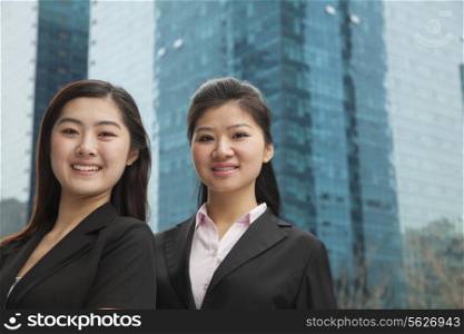 Portrait of two young businesswomen outdoors among skyscrapers