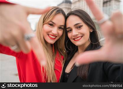 Portrait of two young friends spending good time together outdoors at the street. Lifestyle and friendship concepts.