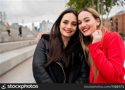 Portrait of two young friends spending good time together outdoors at the street. Lifestyle and friendship concept.