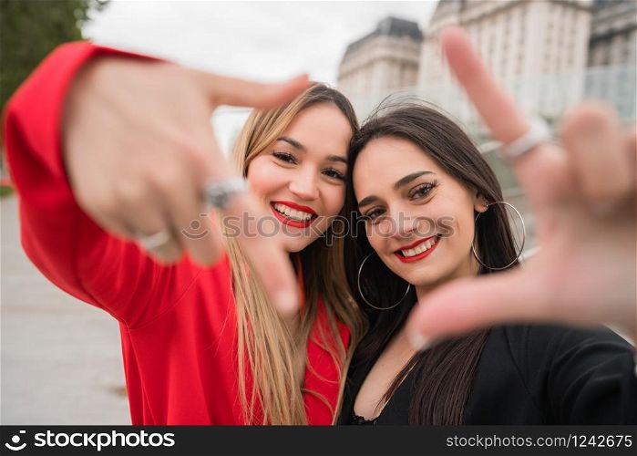 Portrait of two young friends spending good time together outdoors at the street. Lifestyle and friendship concepts.