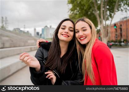 Portrait of two young friends spending good time together outdoors at the street. Lifestyle and friendship concept.