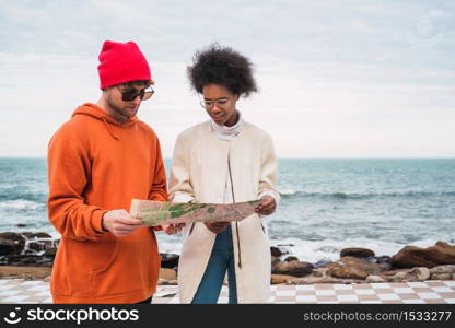 Portrait of two young friends traveling together, with a map and looking for directions. Travel concept.