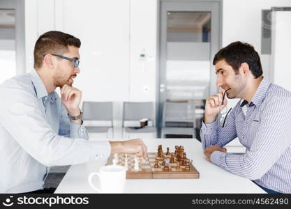 Portrait of two young man playing chess . Portrait of two young man playing chess in office