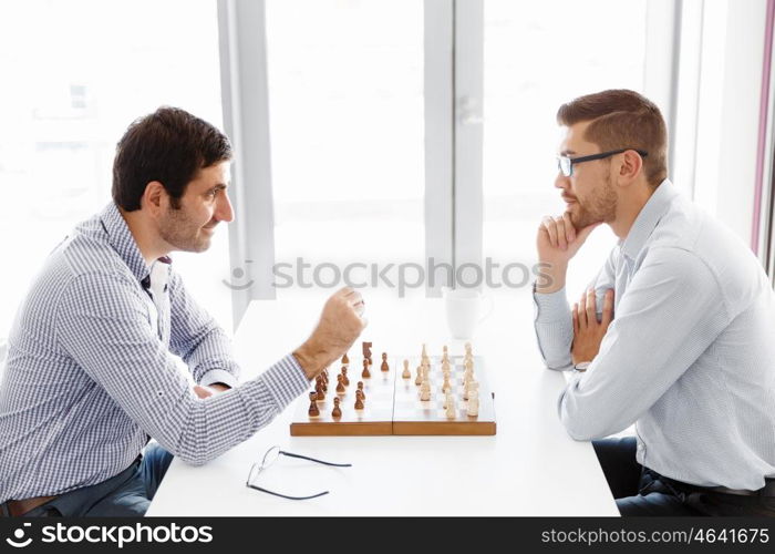 Portrait of two young man playing chess . Portrait of two young man playing chess in office