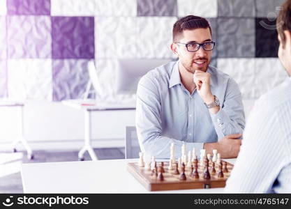 Portrait of two young man playing chess . Portrait of two young man playing chess in office