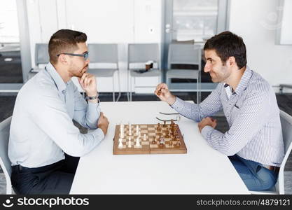 Portrait of two young man playing chess . Portrait of two young man playing chess in office