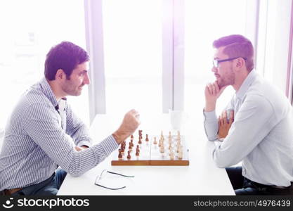 Portrait of two young man playing chess . Portrait of two young man playing chess in office