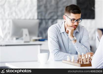 Portrait of two young man playing chess . Portrait of two young man playing chess in office