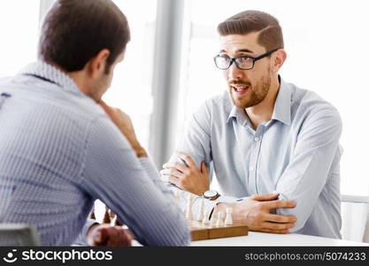 Portrait of two young man playing chess . Portrait of two young man playing chess in office