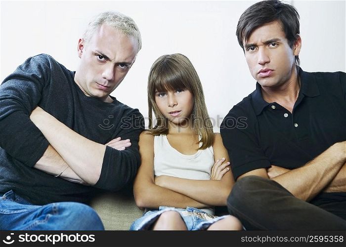 Portrait of two young men and a girl sitting on a couch