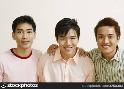 Portrait of two young men and a mid adult man posing and smiling