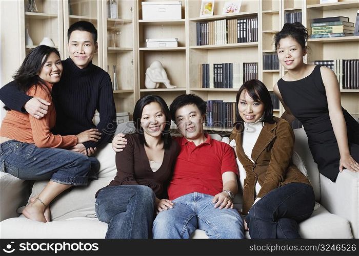 Portrait of two young men and four young women on a couch
