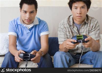 Portrait of two young men playing video game