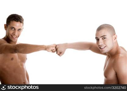 Portrait of two young men with their fists together