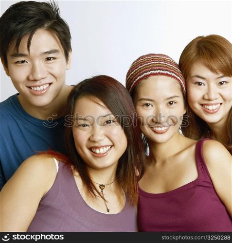 Portrait of two young men with three young women posing and smiling