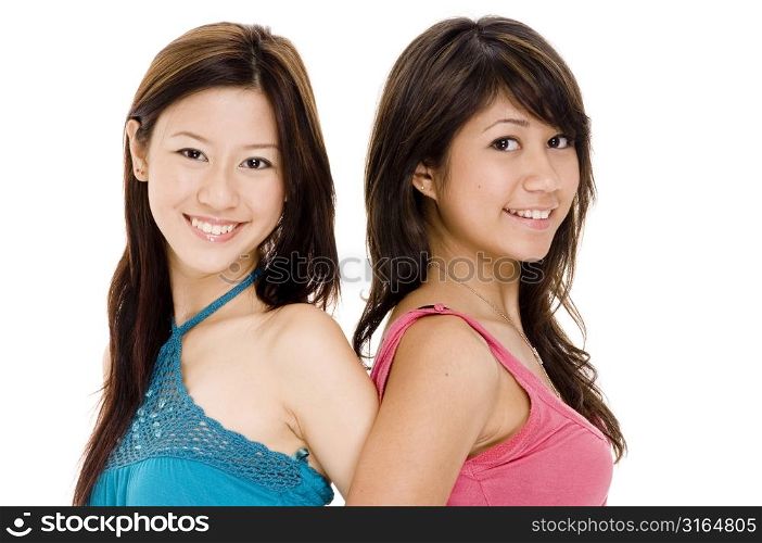 Portrait of two young woman back to back and smiling