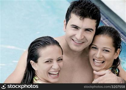 Portrait of two young women and a young man in a swimming pool