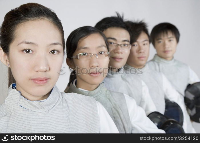 Portrait of two young women and three young men in a row