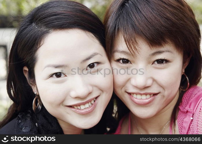 Portrait of two young women cheek to cheek