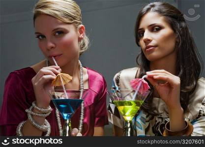 Portrait of two young women drinking cocktail