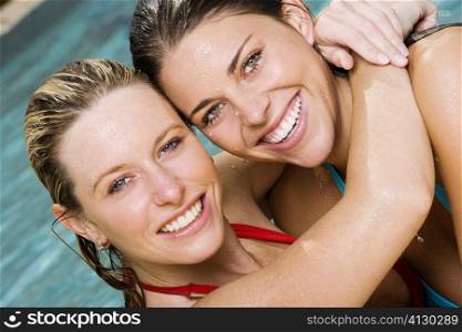 Portrait of two young women hugging in a swimming pool