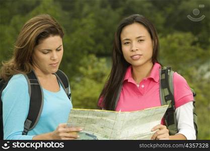 Portrait of two young women looking at a map