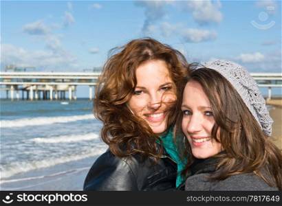Portrait of two young women on the beach on a beautiful autumn afternoon