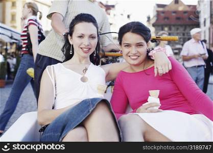 Portrait of two young women sitting in a rickshaw
