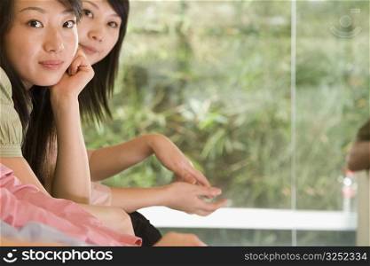 Portrait of two young women sitting side by side