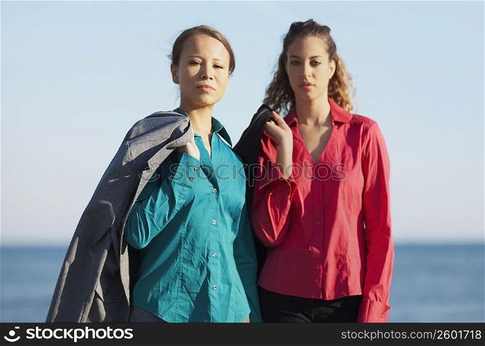 Portrait of two young women standing on the beach