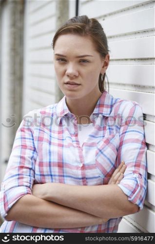 Portrait Of Unhappy Teenage Girl In Urban Setting