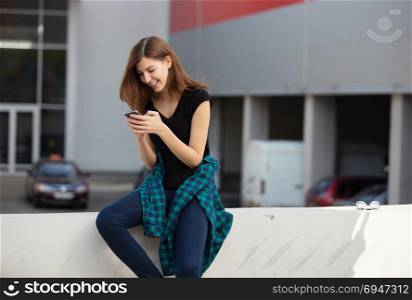 Portrait of urban fashionable girl using smart phone outdoors in the city. Portrait of urban fashionable girl using smart phone outdoors in the city.