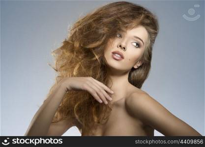 portrait of very sexy girl posing with naked shoulders and bushy creative head. wild hair-style