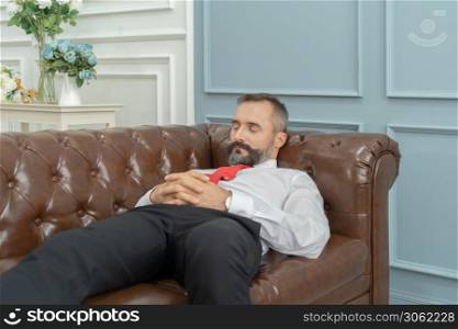 Portrait of vintage business blonde, white man person sleeping, resting, napping, and lying on sofa to sleep and relax. He is tired and exhausted from work in office in break time.