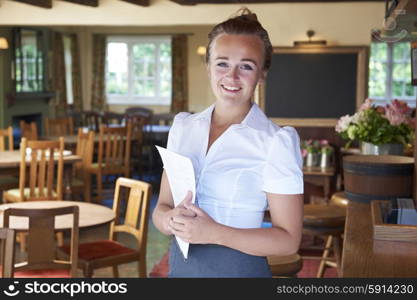 Portrait Of Waitress Holding Menu In Restaurant