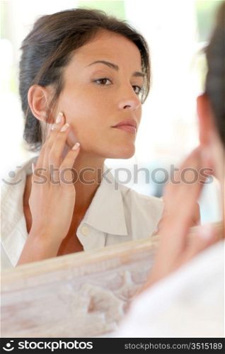 Portrait of woman applying foundation makeup on her face