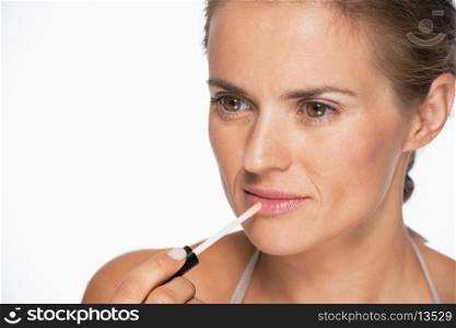 Portrait of woman applying lip gloss