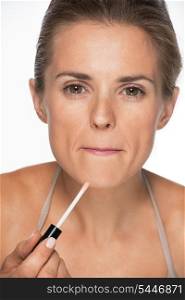 Portrait of woman applying lip gloss