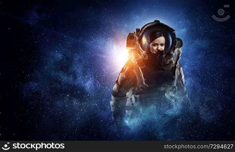 Portrait of woman astronaut on dark starry sky background. Mixed media. Attractive woman in spacesuit