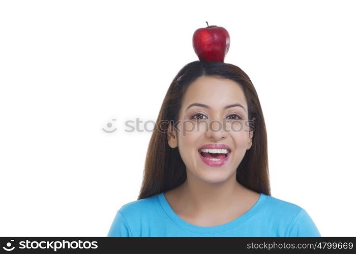 Portrait of woman balancing apple on head