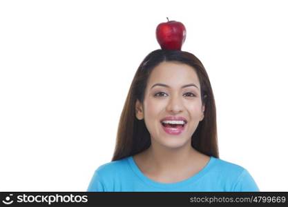 Portrait of woman balancing apple on head