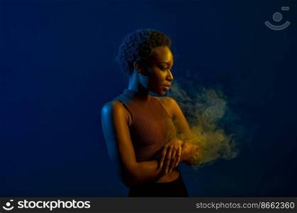 Portrait of woman blowing smoke curls from mouth over dark studio background in neon light. Passion woman blowing smoke curls