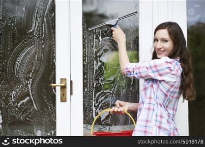 Portrait Of Woman Cleaning House Windows